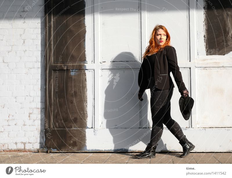 . Feminine 1 Human being Wall (barrier) Wall (building) Door Pants Jacket Boots Cap Red-haired Long-haired Observe Going Looking Athletic Self-confident