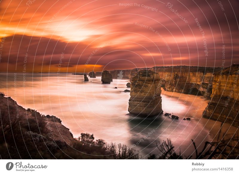 Twelve Apostles in the Evening Red Landscape Clouds Sunrise Sunset Rock Waves Coast Beach Bay Ocean Great Ocean Road Cliff Discover Relaxation Vacation & Travel