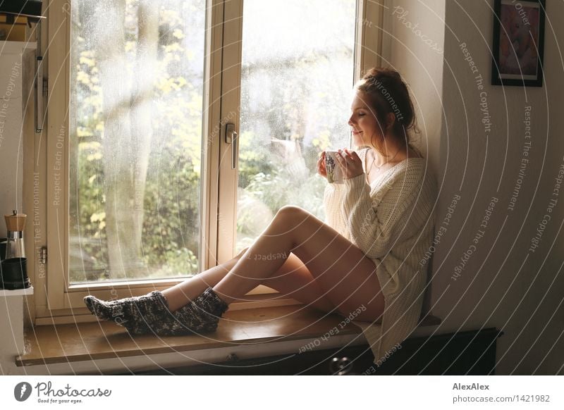 Sexi young girl in bra and jeans shorts relaxing by window Stock Photo