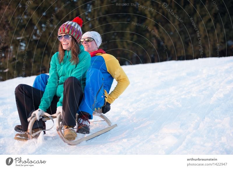Young couple sledging Joy Leisure and hobbies Winter Snow Winter vacation Winter sports Sleigh Ski run Human being Masculine Feminine Young woman