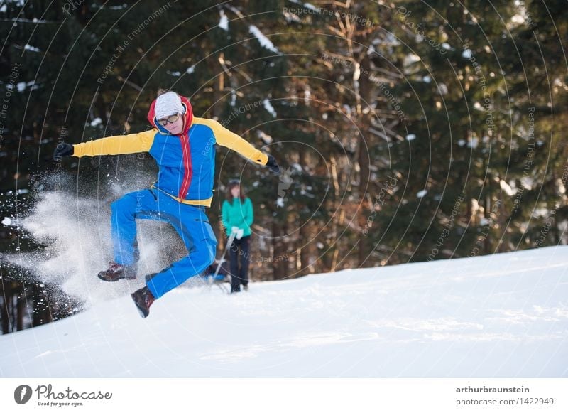 Young man jumps into the air and has fun in the snow Joy Tourism Trip Winter Snow Winter vacation Hiking Winter sports Human being Masculine Feminine