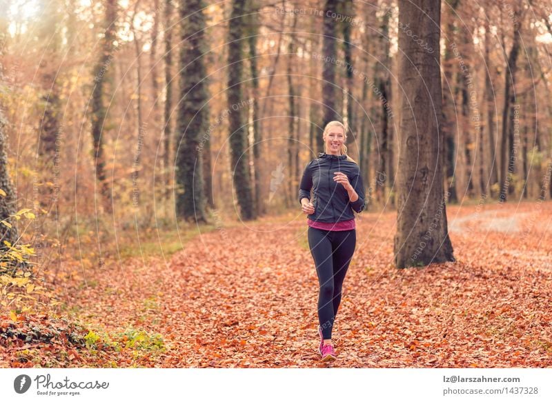 Pretty fit young woman jogging in woodland Diet Lifestyle Body Face Sports Jogging Woman Adults Nature Autumn Forest Blonde Fitness Smiling Fresh athletic