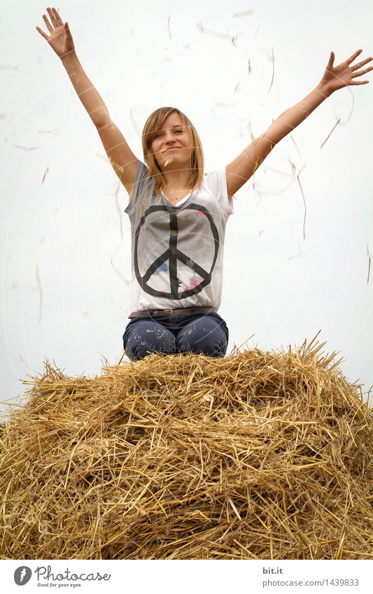 Peace sign on t shirt of teenager, youth, young woman. Teenager on straw bale, wishes peace. Peace in Ukraine and the world. Peace in Ukraine. Youth wishes peaceful world, without violence and war.