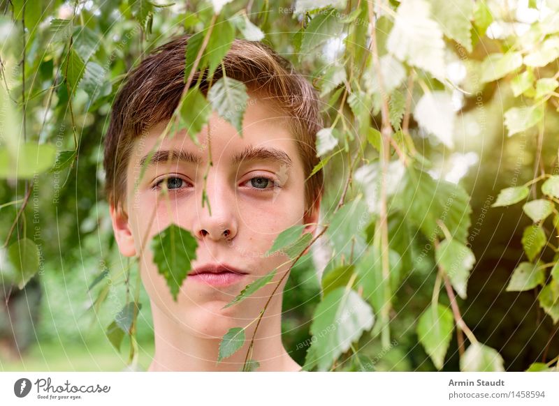 smiling teenager behind some leaves of a tree Lifestyle Harmonious Contentment Senses Relaxation Human being Masculine Young man Youth (Young adults) Head 1