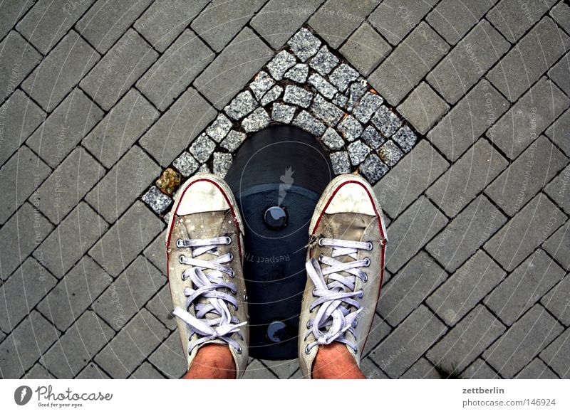 pile standing Street Traffic lane Sidewalk Cobbled pathway Pave Cobblestones Paving stone Bollard Pole Wooden stake Border Boundary Shadow Human being Stand