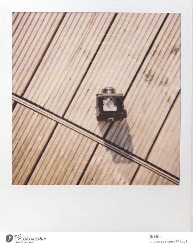 Lubitel Polaroid Speed Expensive Lomography Camera Take a photo Balcony Wooden floor Floor covering Wooden board Summer Shadow Minimalistic Furrow Across