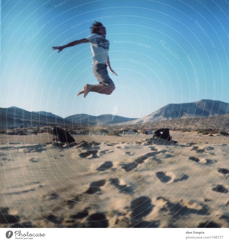 stay high Human being Jump Beach Sand Desert Horizon Blue Footprint Joy Tall Sky Middle Bag Fuerteventura Landscape format Roll film Mountain sotavento