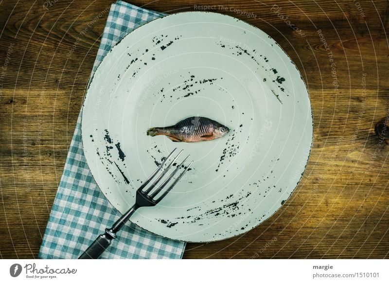 A plate with a small fish on it, a fork, a napkin on a wooden table Food Fish Nutrition Lunch Organic produce Diet Fasting Plate Fork Healthy Cook Animal