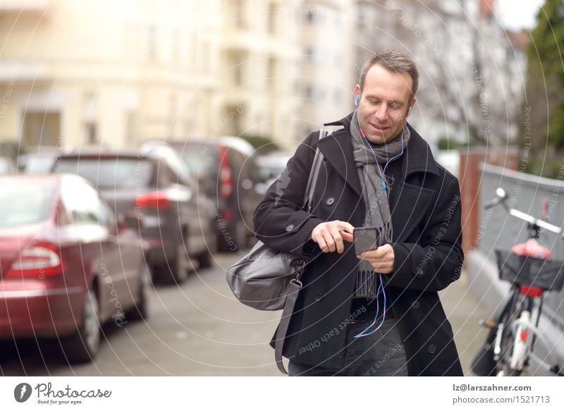 Attractive man in winter fashion checking his mobile Winter Business To talk Telephone Technology Masculine Man Adults 1 Human being 30 - 45 years Street