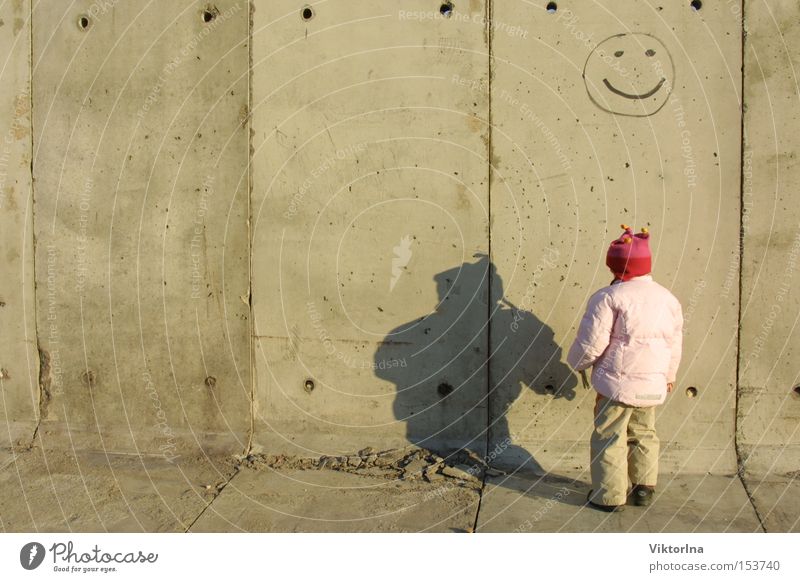 Smile! Grief Happiness Smiley Wall (barrier) Wall (building) Child Defiant Shadow Graffiti Beautiful weather Timidity Fear Concrete Sadness