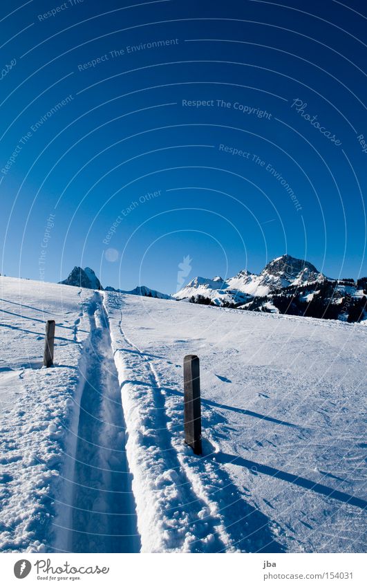 offroad Snow White Mountain Tracks Skiing Ski tracks Driving Glide Fence Fence post Wooden stake Shadow Snowscape Landscape