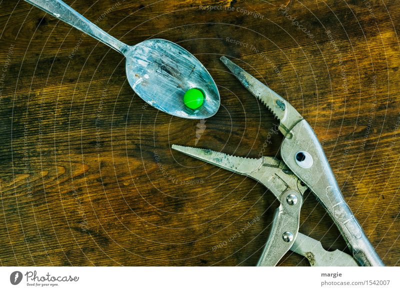Bitter pill! A pair of pliers with eyes gets a green pill on a spoon Spoon Health care Nursing Illness Work and employment Craftsperson Services Tool