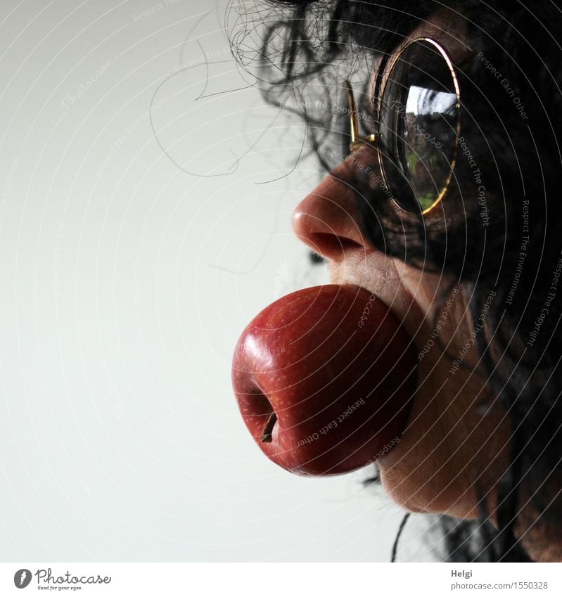 Close up of a female face with sunglasses and black hair and a whole apple in her mouth Food Apple Organic produce Human being Feminine Woman Adults