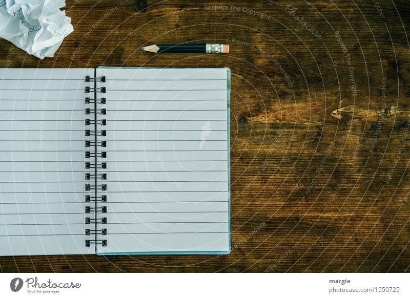 Lined notebook with spiral, pencil and a crumpled piece of paper on an old wooden table Education School Study Work and employment Profession Office work