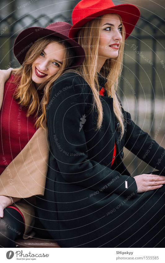 Two girls sitting on the bench and smile Lifestyle Joy Happy Beautiful Face Meeting To talk Human being Feminine Girl Woman Adults Friendship Autumn Fashion Hat