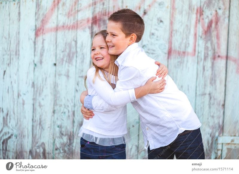 two children, a boy and a girl, hugging and laughing, looking to the side Girl Boy (child) Brothers and sisters Infancy 2 Human being 8 - 13 years Child