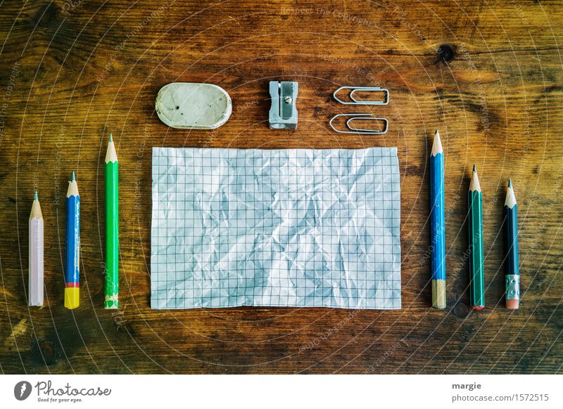 Notes and pencils, eraser, sharpener and paper clips on an old wooden table Education School Study Professional training Work and employment Office work