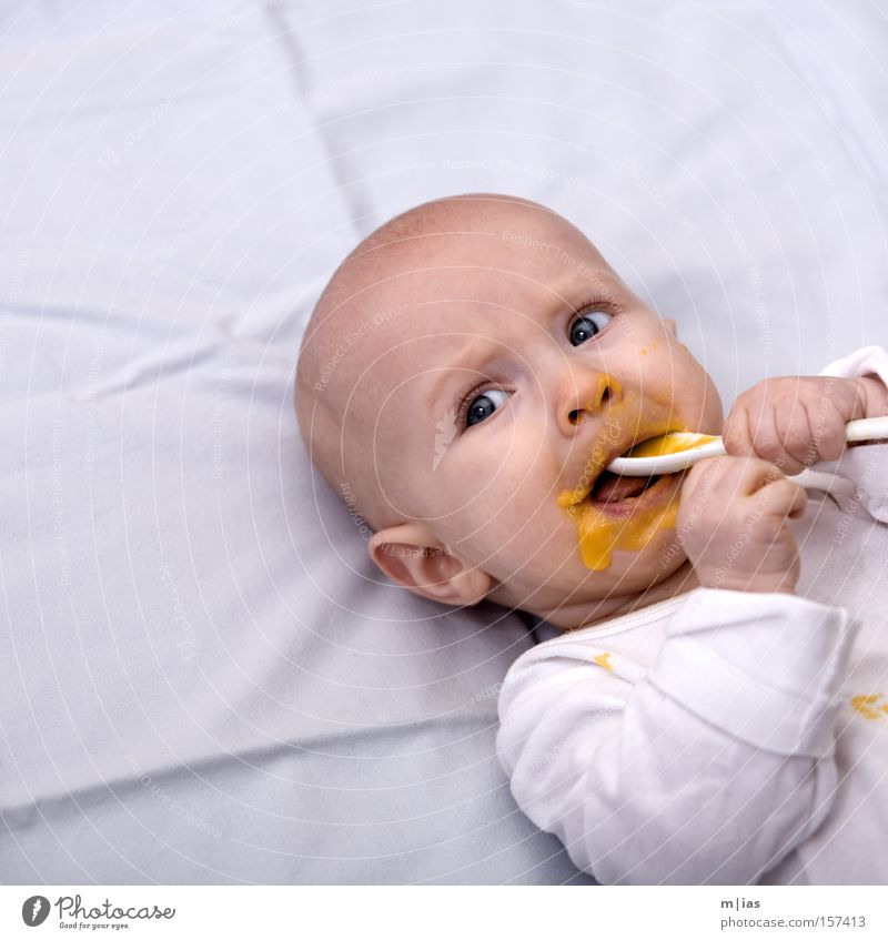 Hit rate. Baby Puree Nutrition Spoon White Portrait photograph Mouth Hand Daub Eating Child's portrait Face of a child Bright background Isolated Image Lie