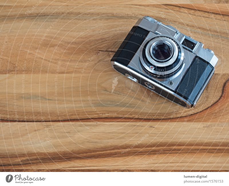 analogue 35mm camera on brown wooden table Camera Technology Old Retro Black Silver image Analog Appearance Ancient Equipment Background picture Aperture