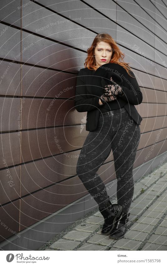. Feminine 1 Human being Wall (barrier) Wall (building) Sidewalk Pants Jacket Boots Hat Red-haired Long-haired Observe Looking Stand Wait Beautiful Under