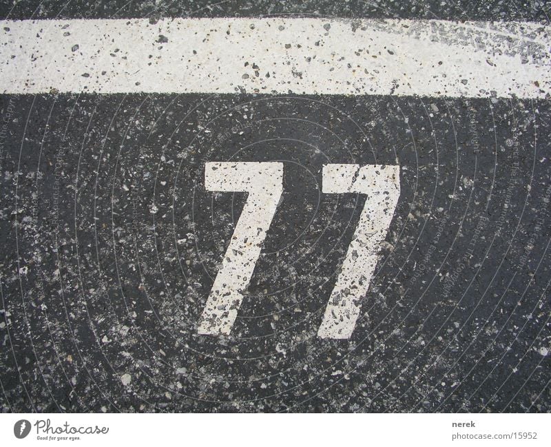 77 - holy number Digits and numbers Tar Parking lot Asphalt Skid marks Line Tracks Christianity Transport Street wise Signs and labeling