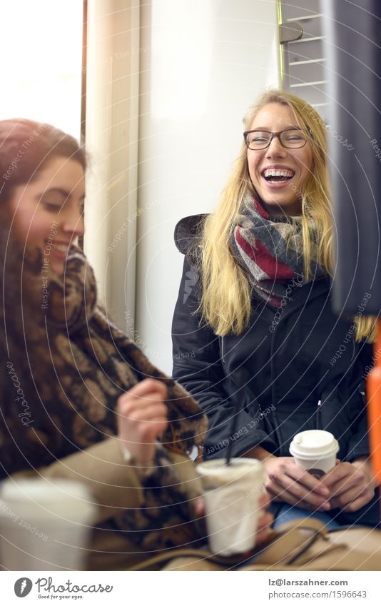 Two seated blond and brunette friends Coffee Happy Woman Adults Friendship 2 Human being 18 - 30 years Youth (Young adults) Eyeglasses Scarf Brunette Blonde