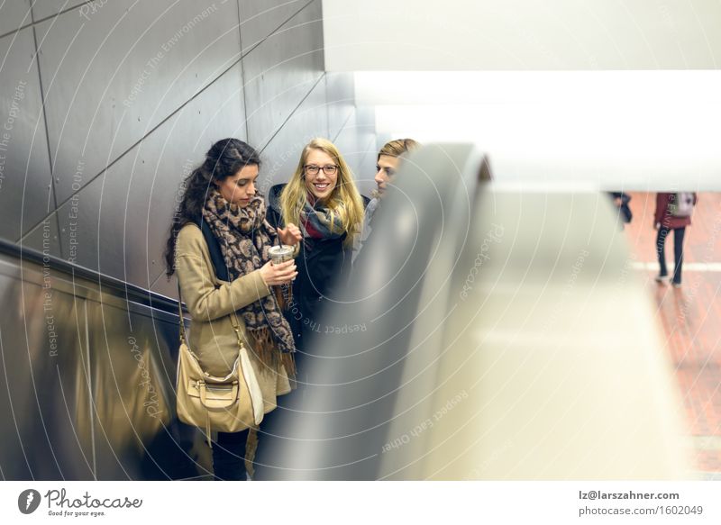 Three young women moving up escalator Happy Woman Adults Friendship 3 Human being 18 - 30 years Youth (Young adults) Railroad Escalator Scarf Brunette Blonde