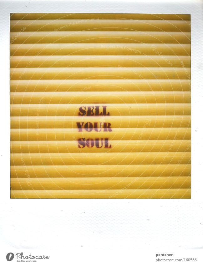 "Sell your soul" is written on the yellow shutter of a store. History, betrayal, soul. Culture Youth culture Subculture built Decoration Characters Graffiti