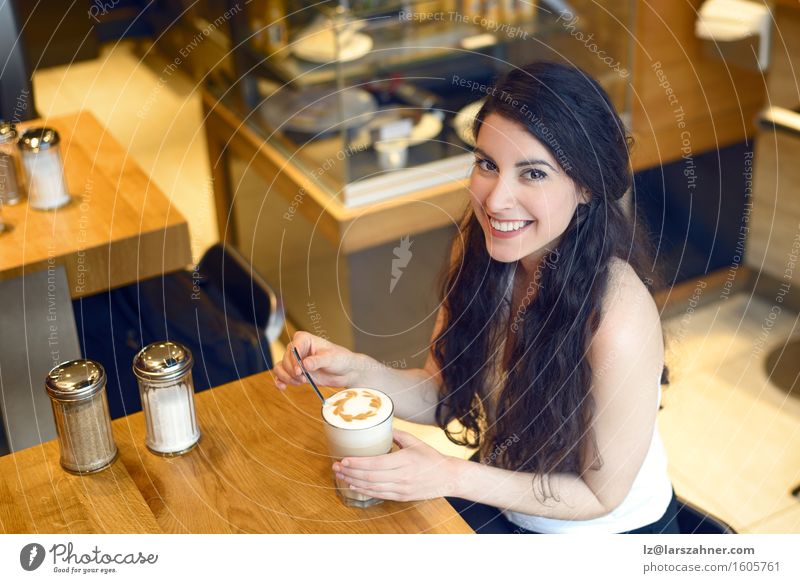 Smiling brunette woman sitting in a bar drinking coffee Coffee Latte macchiato Lifestyle Beautiful Relaxation Table Woman Adults 1 Human being 18 - 30 years