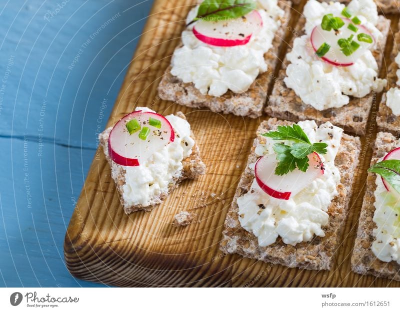 Crispbread with cottage cheese radishes and herbs Herbs and spices Wood Blue Cream cheese Radish Chives Dill Parsley beetroot leaves Wooden board Snack