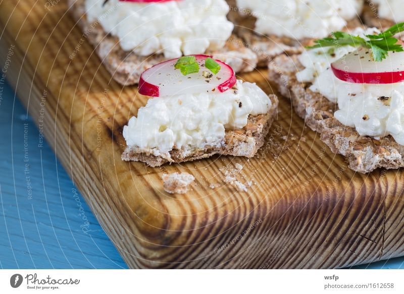 Crispbread with cottage cheese radishes and herbs Herbs and spices Wood Blue Cream cheese Radish Chives Dill Parsley beetroot leaves Wooden board Snack