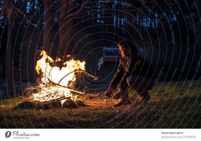 Man lights a fire in the fireplace in nature at night Leisure and hobbies Vacation & Travel Tourism Adventure Camping Summer Mountain Hiking Human being Adults