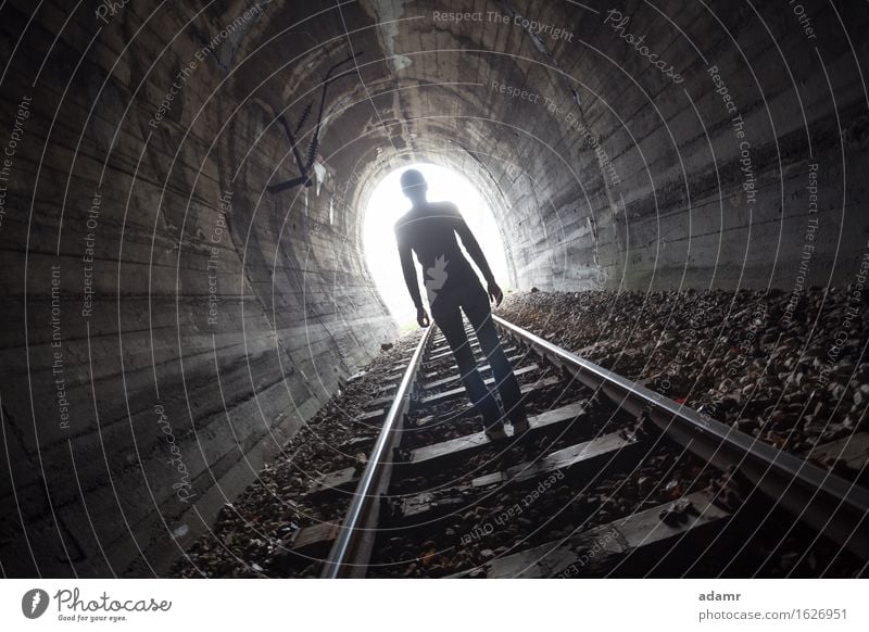 Man in a tunnel looking towards the light adventure afterlife arched architecture asylum bright dark daylight escape enlightenment faith future hope