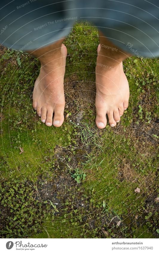 Young man stands barefoot on moss a Royalty Free Stock Photo from Photocase