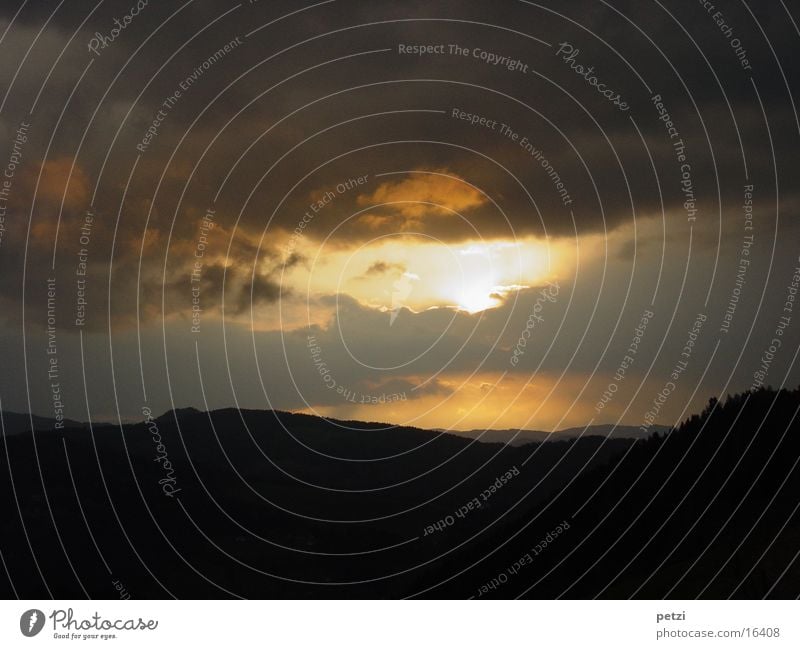 The day comes to an end Mountain Clouds Forest Yellow Gray Black Dusk sun hole Colour photo Exterior shot Copy Space top Copy Space bottom Silhouette Long shot