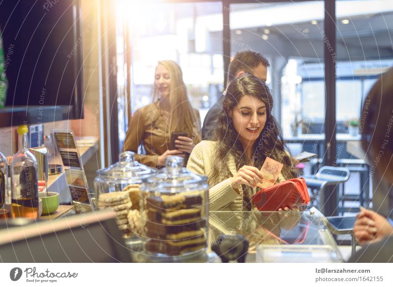Attractive young woman paying in a shop Shopping Happy Woman Adults Paying attractive Bank note bar briunette Cafeteria Cashier Copy Space counter Customer