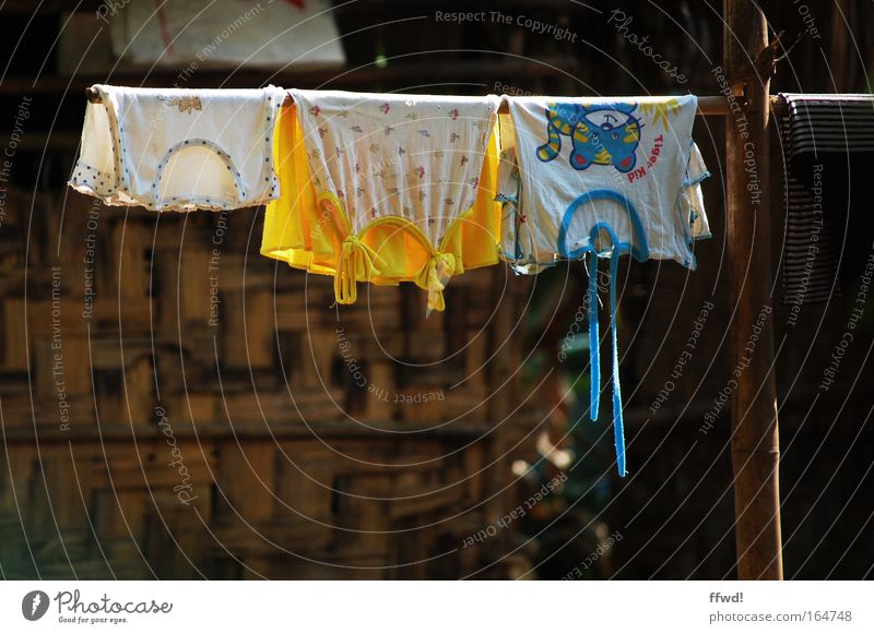 dry season Colour photo Exterior shot Day Sunlight Shallow depth of field Living or residing Asia Village Hut Terrace Clothing T-shirt Hang Cleaning Simple