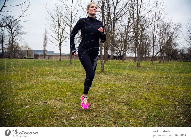 Woman wearing sportswear exercising during winter Stock Photo by