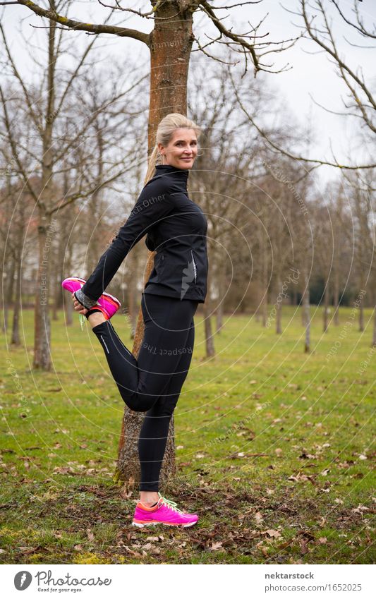 woman stretching her legs in park Lifestyle Body Wellness Sports Human being Woman Adults Park Fitness Smiling Stand Athletic Thin Friendliness limbering up