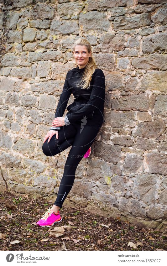 portrait of woman leaning against a wall in park Lifestyle Happy Body Wellness Sports Human being Woman Adults Park Stone Fitness Smiling Athletic Thin