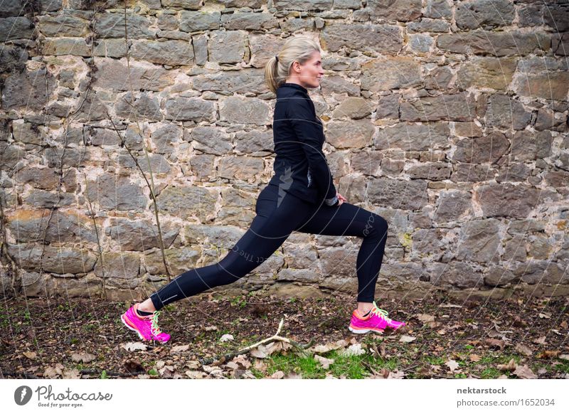 Woman stretching her body in front of ancient wall in park Lifestyle Body Wellness Sports Human being Adults Park Stone Touch Fitness Athletic Mobility Practice