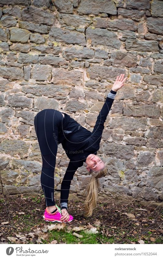 Woman stretching her body in front of ancient wall in park Lifestyle Happy Body Wellness Sports Human being Adults Park Stone Fitness Smiling Athletic