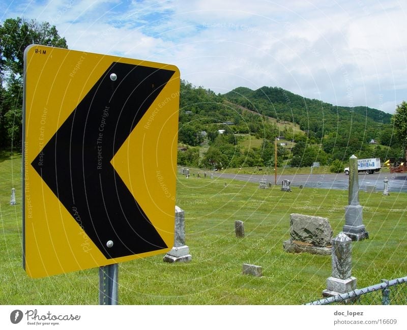 left Curve Yellow Black Warning label Green Cemetery Meadow Grave Signs and labeling Landscape USA traffic sign pointing left that predicts a curve...