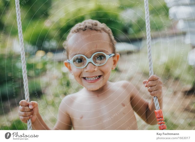 young boy on a swing Joy luck Life Well-being Summer Summer vacation Living or residing Garden Human being Toddler Infancy 1 1 - 3 years Eyeglasses Short-haired