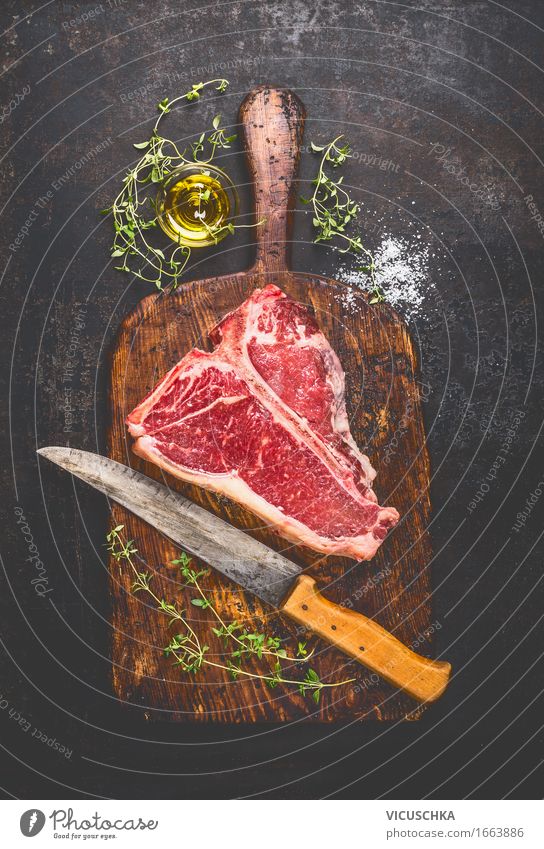 T-Bone Steak on old cutting board with knife Food Meat Herbs and spices Cooking oil Nutrition Lunch Dinner Picnic Organic produce Knives Style Healthy Eating