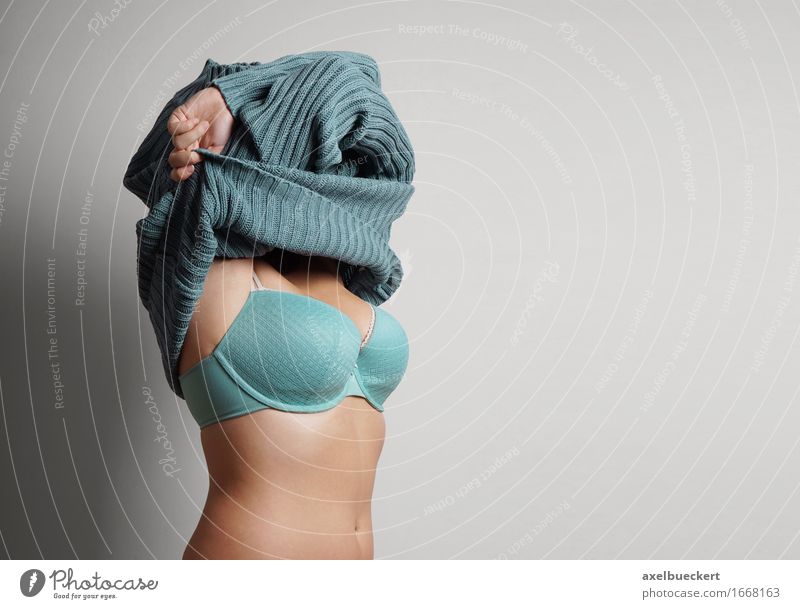 woman pulling off sweater - a Royalty Free Stock Photo from Photocase