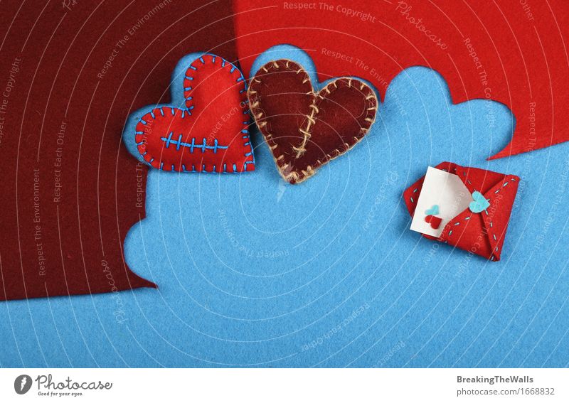 Two stitched toy hearts, brown and red cut out on blue felt Leisure and hobbies Handcrafts Art Work of art Piece of paper Toys Heart Communicate Love Near Blue