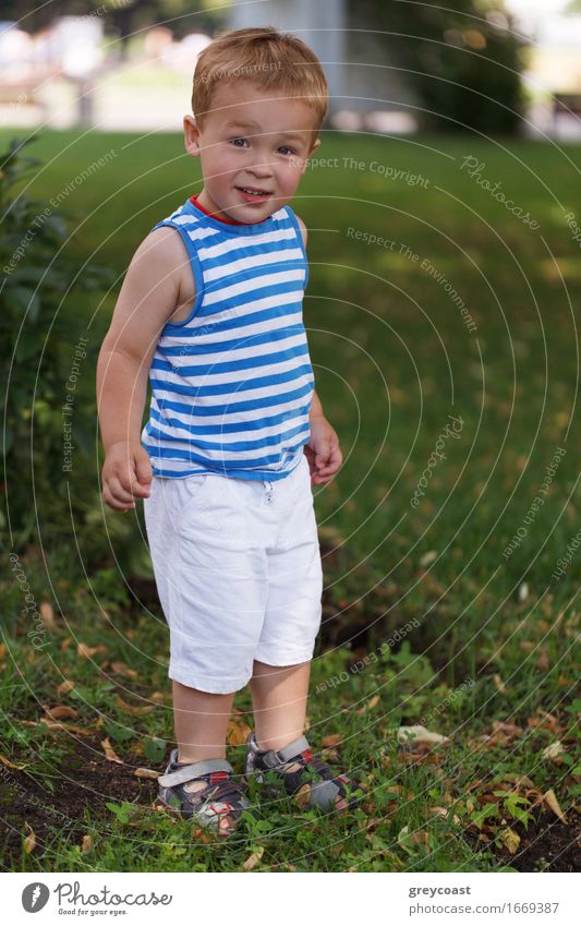 Portrait of 3 year old boy in striped vest in the city park looking to the photographer and smiling Lifestyle Joy Happy Beautiful Face Leisure and hobbies