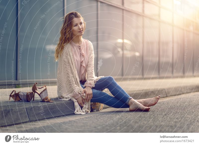 Serious pretty young woman sitting on kerb Beautiful Face Feminine Woman Adults 1 Human being 18 - 30 years Youth (Young adults) Street Fashion High heels