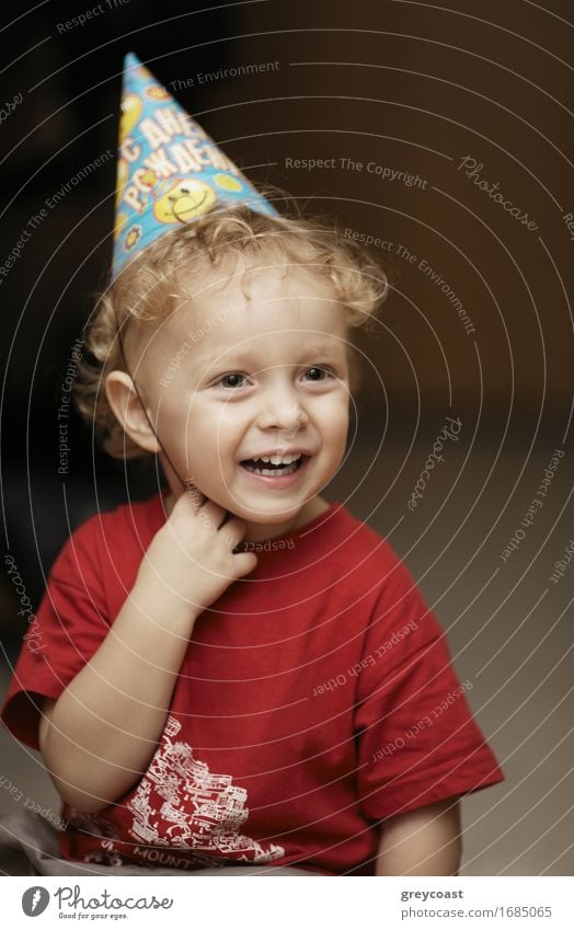 Cute happy young boy in a party hat laughing with enjoyment as he celebrates a birthday or Christmas Lifestyle Joy Happy Beautiful Face Decoration